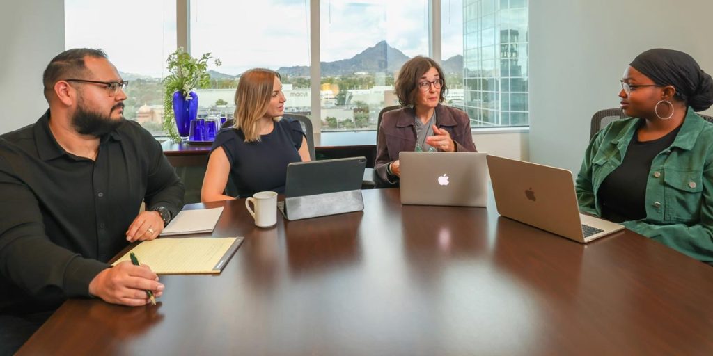 Meeting at Cizek Associates with Arizona mountain in the window