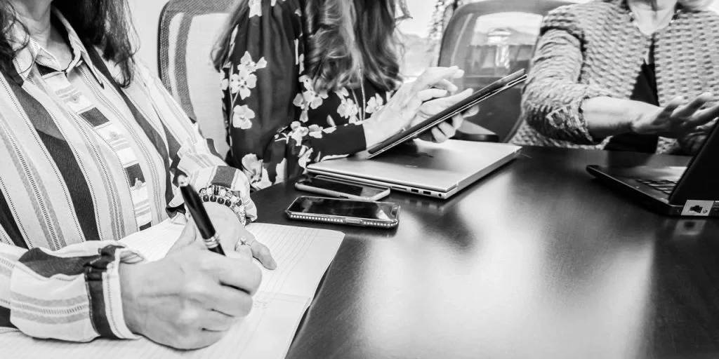 3 women taking notes at a meeting